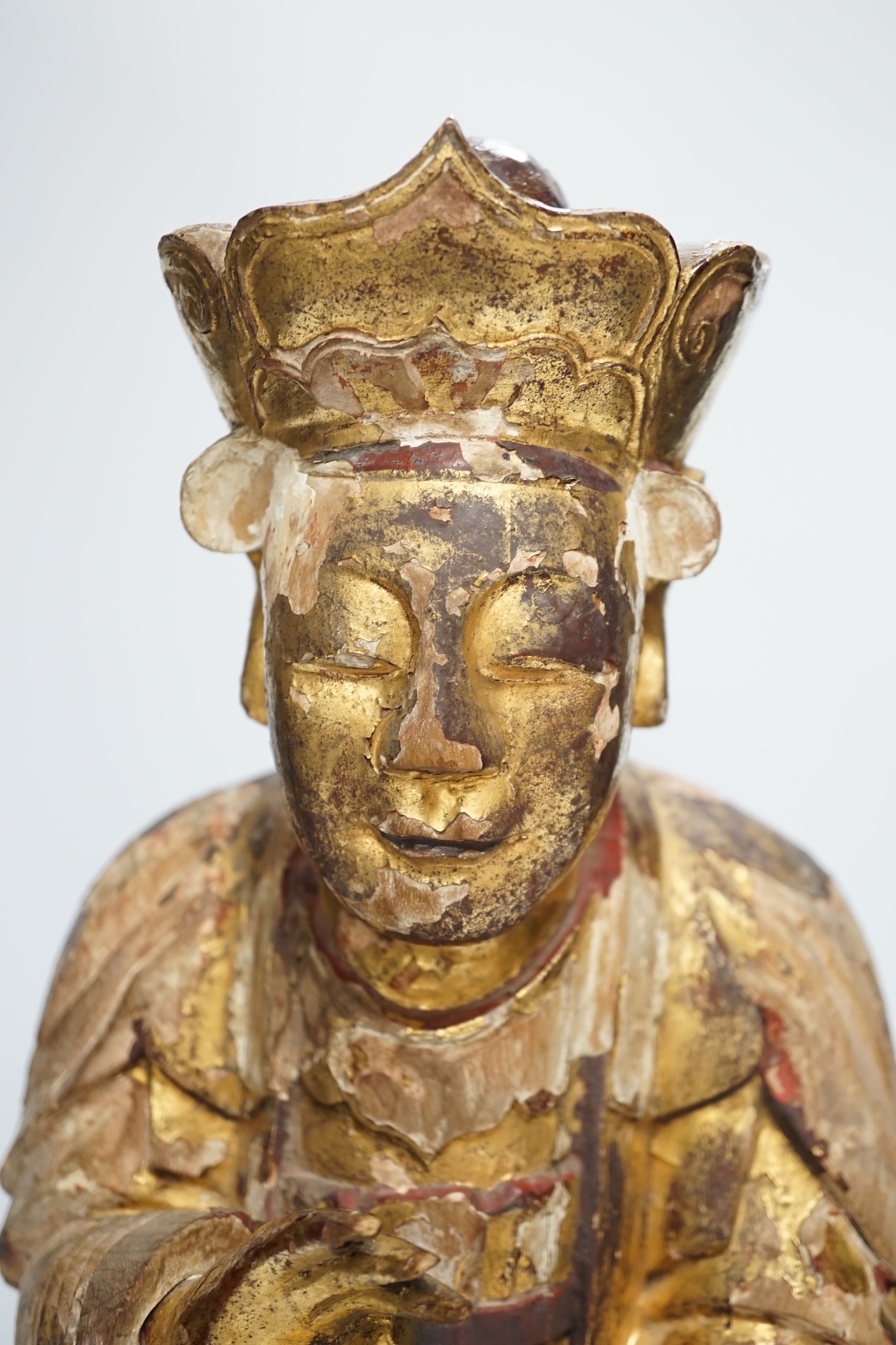 A Chinese gilt lacquered wooden figure of Buddha, possibly Yuan to Ming, 42cm high. Condition - poor to fair, losses to lacquer overall